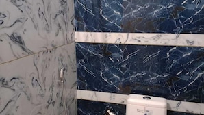 Un baño con inodoro, bidé y cubo de basura.
