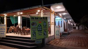 Un restaurante llamado Swati con terraza y un letrero que enumera varios platos.