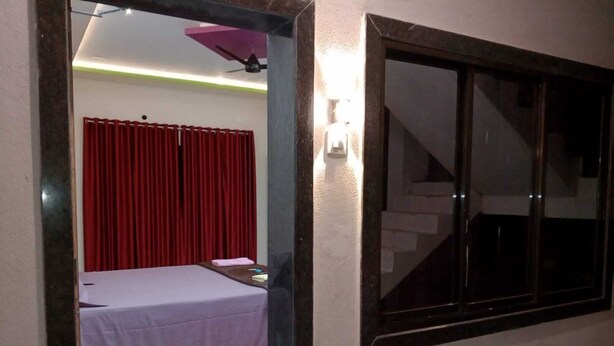 Una habitación con una cama, un ventanal y una escalera.
