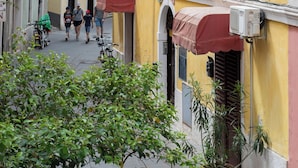 A narrow street with buildings on either side, featuring balconies and awnings. - Apartments Leonel Piran  (Piran)