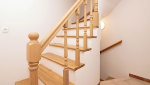 A wooden staircase with a handrail and a light fixture on the wall. - Apartments Leonel Piran  (Piran)