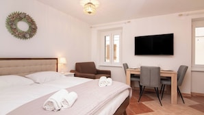 A hotel room with a bed, a desk, a chair, a television, and a window. - Apartments Leonel Piran  (Piran)