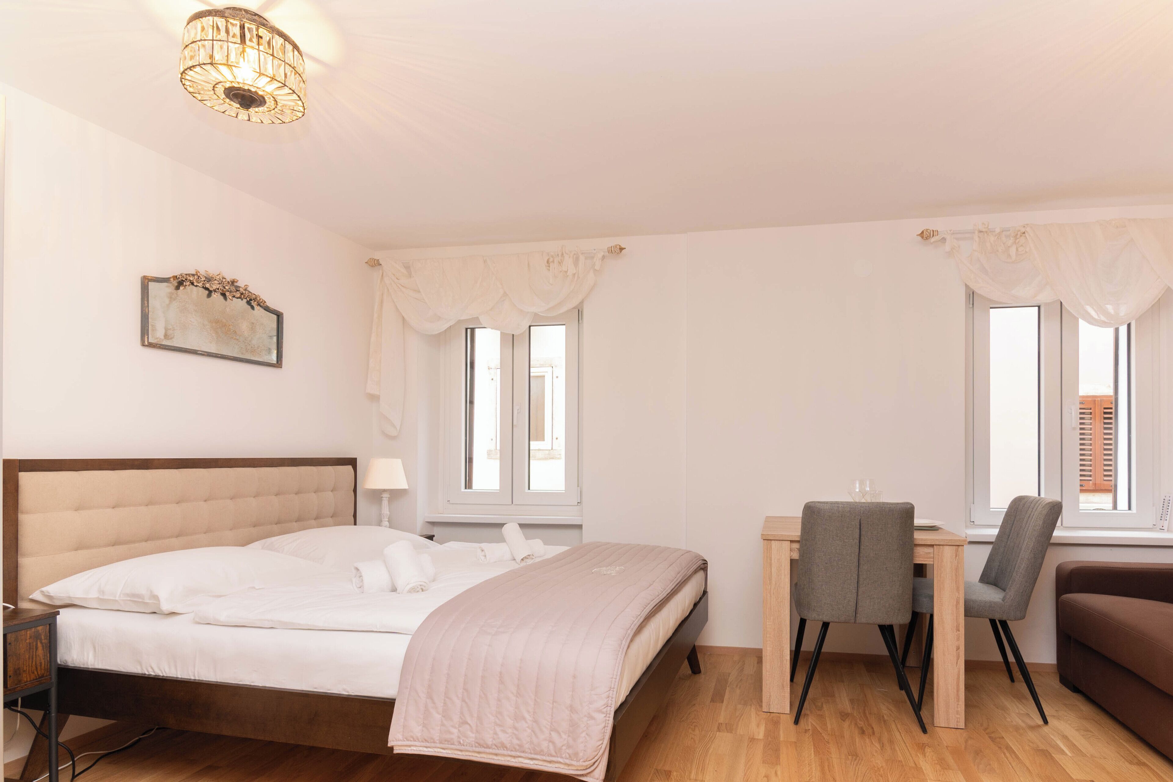 A bedroom with a bed, bedside table, desk, and chair.