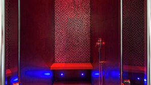 A room with a red carpet, a patterned wall, and a stage area with blue lighting. - 7 Inn Spanish Steps (Rome)