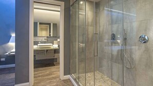 A modern bathroom with a glass-enclosed shower, a large mirror, and a vanity with a sink and towel rack. - 7 Inn Spanish Steps (Rome)