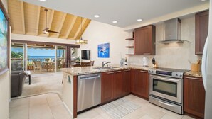 A modern kitchen with granite countertops, stainless steel appliances, and wooden cabinets.