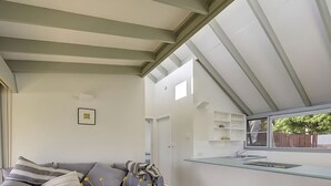 Un interior moderno con un sofá, una zona de cocina y una ventana.