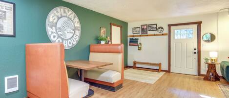 A cozy living room with a wooden floor, a sofa, a small table, and a door.