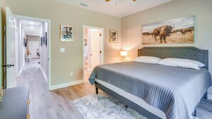 Una camera da letto con un letto, una ventola a soffitto e un dipinto di un toro.