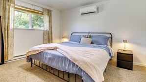 A bedroom with a bed, bedside lamps, an air conditioner, and a window with curtains. - 1 Mi to Snoqualmie River: Pet-friendly Getaway (Carnation)