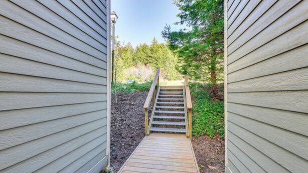 A wooden deck leading to a house with siding. - Located in Snowshoe Resort: Townhome w/ Deck! (Snowshoe)