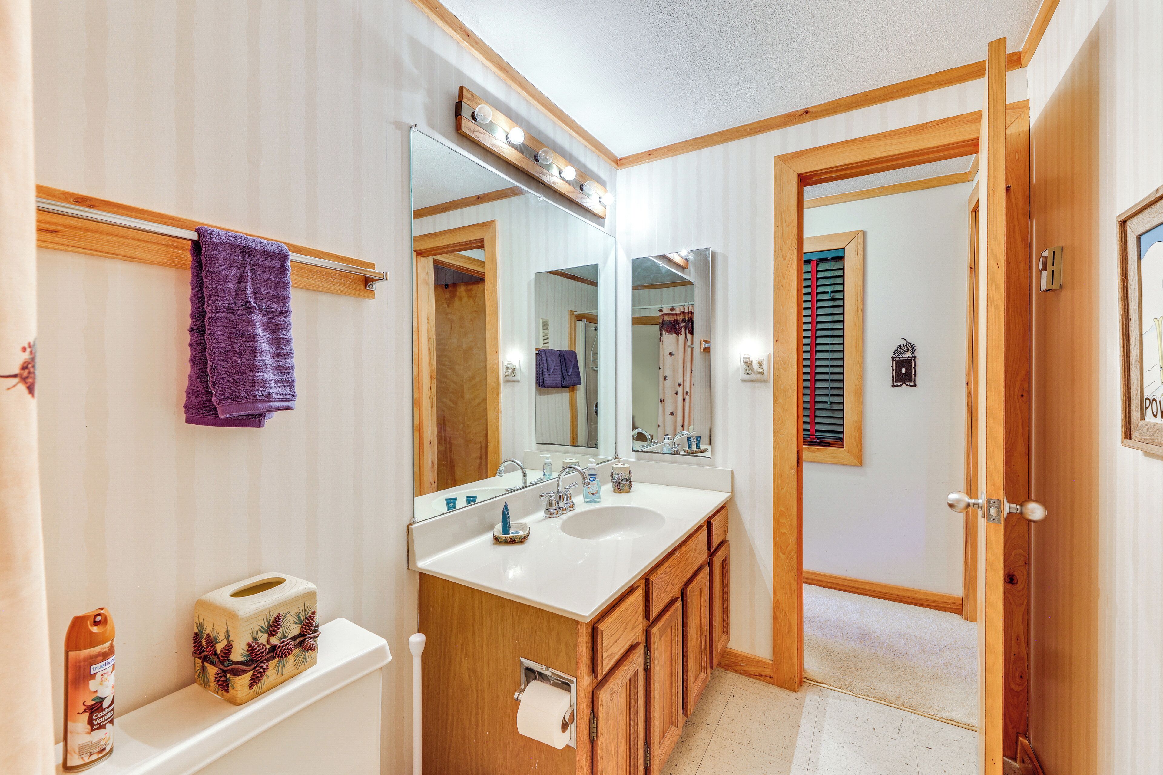 Un baño con tocador de madera, un espejo grande y un lavabo doble.