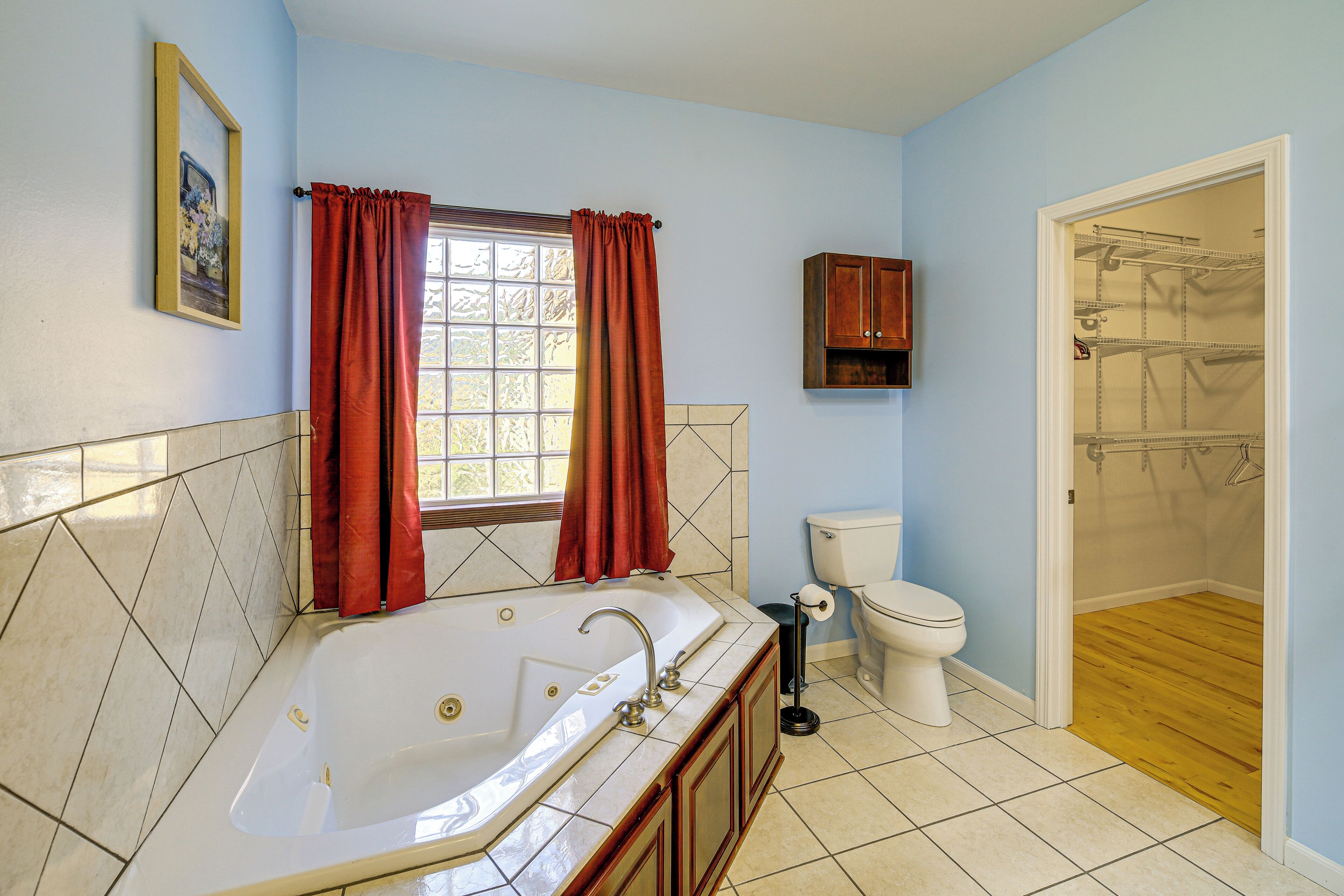 A bathroom with a bathtub, toilet, and shower area.
