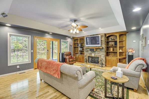 A spacious living room with a fireplace, a ceiling fan, and a large TV. - Breaks Home: 3 Mi to ATV Trails! (Breaks)