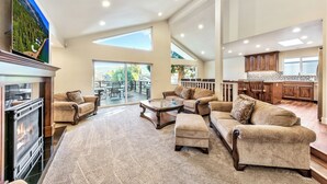 A spacious living room with a fireplace, comfortable seating, and a large TV. - Luxury Keys Living: 3BR, Pool, Boat Dock, & BBQ (South Lake Tahoe)