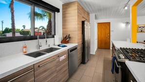 A modern kitchen with a stainless steel refrigerator, a dishwasher, and a gas stove.