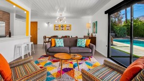 A modern living room with a sofa, coffee table, and colorful rug.