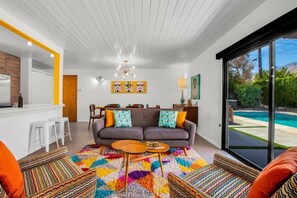 A modern living room with a sofa, coffee table, and colorful rug.
