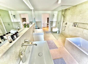 Un baño moderno con un lavamanos grande, una bañera y una zona de ducha.