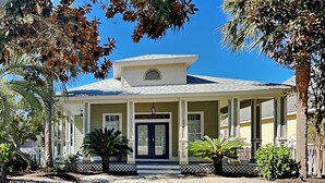 Une maison à deux étages avec un porche à l’avant, un garage et une allée.