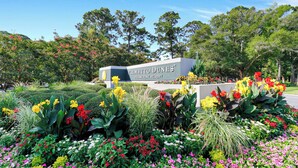 A sign for Palmetto Dunes Oceanfront Resort surrounded by a variety of colorful flowers and lush greenery. - Beautiful villa w/ nature views & screened porch only minutes from the beach (Hilton Head Island)
