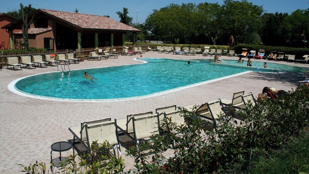 A pool area with lounge chairs and a covered seating area. - APARTMENT A FEW KILOMETERS FROM THE BEACH (Sala)