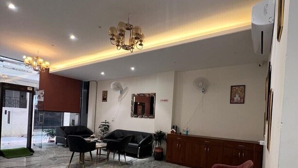 A modern lobby with a marble floor, black and red chairs, a chandelier, and a reception desk. - HOTEL IVORY INN (New Delhi)
