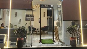 A hotel lobby with a reception desk, seating area, and a staircase leading to an upper floor. - HOTEL IVORY INN (New Delhi)