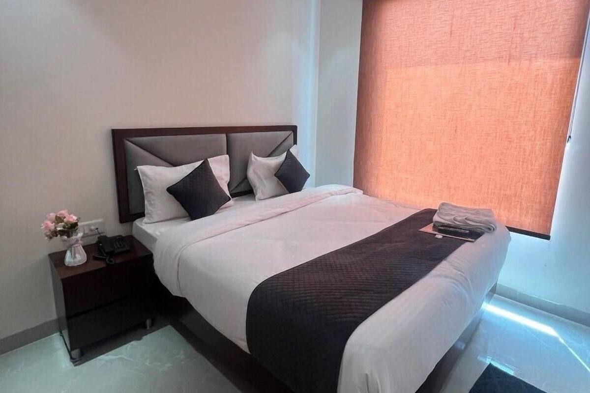 A bedroom with a bed, nightstand, and a ceiling fan.