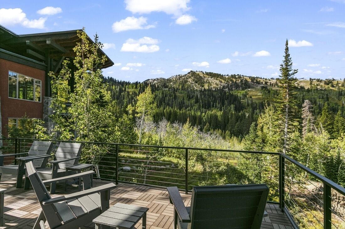 A wooden deck with outdoor seating and a mountain view.