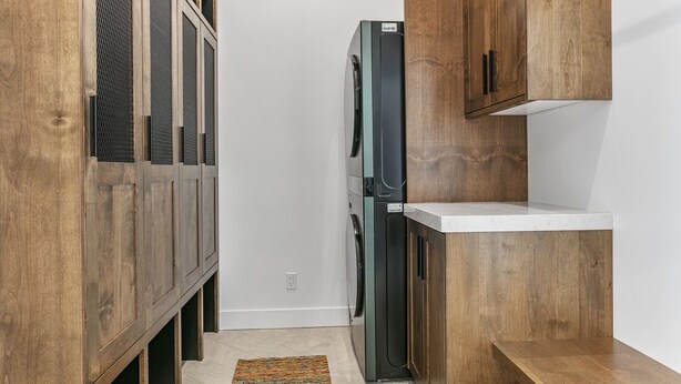 Una cocina compacta con armarios de madera, lavadora integrada y una encimera.