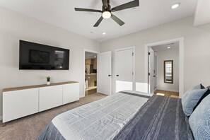 A bedroom with a bed, a TV mounted on the wall, a ceiling fan, and a wardrobe. - Desert Sand Retreat 2 Bedroom Condo (St. George)