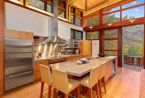 A modern kitchen with a large island, stainless steel appliances, and wooden accents.