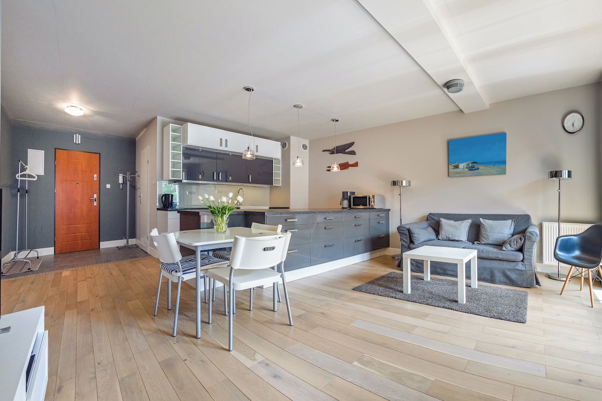 A modern apartment with a dining area, kitchen, and living space.