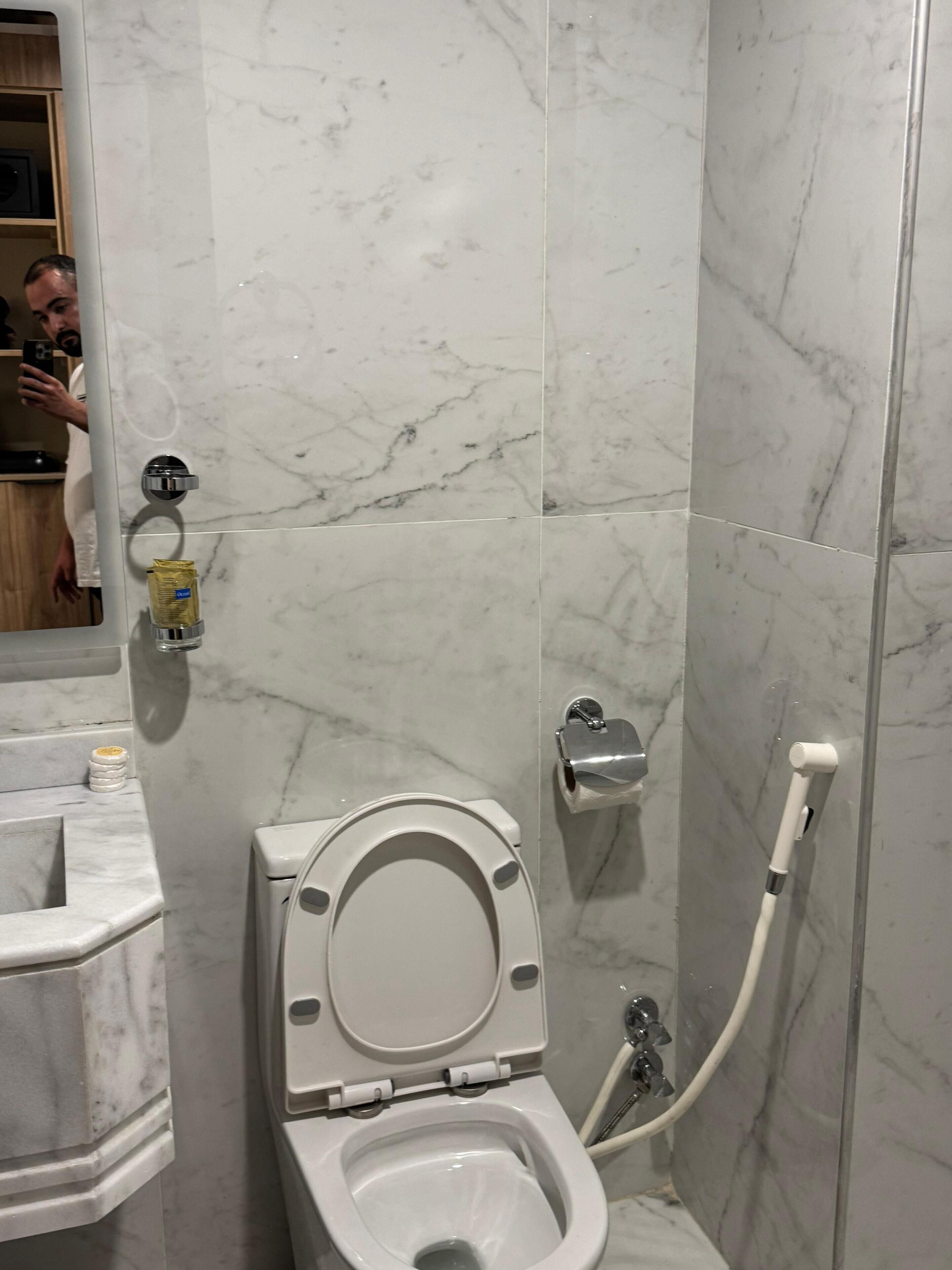Une salle de bain équipée de toilettes, d’un lavabo et d’une douche.