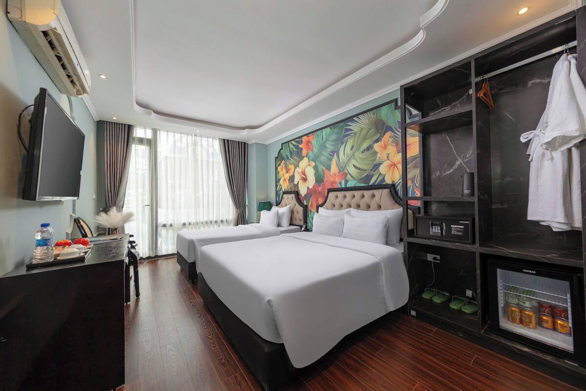 Hotelkamer met twee bedden, een flatscreen televisie, een minibar en een douche.