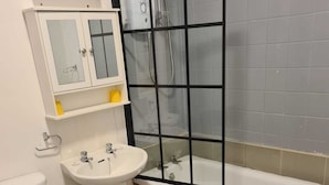 A bathroom with a toilet, sink, and bathtub. - The Eagle and child  (Preston)