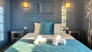 Camera da letto con un letto, due comodini e una lampada a parete.