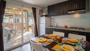 Una cocina con una mesa para el desayuno, un refrigerador y una estufa a gas.