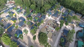 Ett flygbildsbild av ett bostadsområde med flera hus, där varje hus har en tydligt avvikande takfärg.
