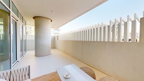 Een modern interieur met een witte tafel, een grote pilaar en een witte scheidingswand.