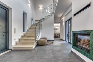 A modern interior with a staircase, a fireplace, and a dining area. - Villa Sunset Bliss| private pool - country views (Corfu)