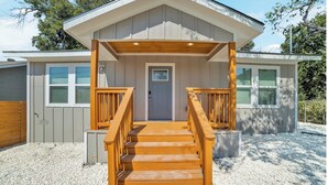 A two-story building with a wooden staircase leading to a front porch.