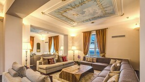 A spacious living room with a large sectional sofa, a coffee table, and a view of the sea through large windows. - Villa Sogno by My Villa Collection (Sant'Agnello di Sorrento)
