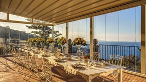 An outdoor dining area with tables set for a meal, overlooking a scenic view of the sea. - Villa Sogno by My Villa Collection (Sant'Agnello di Sorrento)