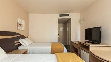 Quarto de hotel com duas camas, uma escrivaninha, uma televisão e um guarda-roupa.
