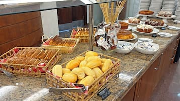 Ein Buffet mit verschiedenen Backwaren, darunter Brot und Gebäck, sowie Beilagen.