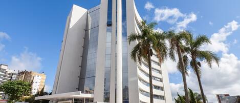 A modern building with a curved facade, large windows, and a flat roof.
