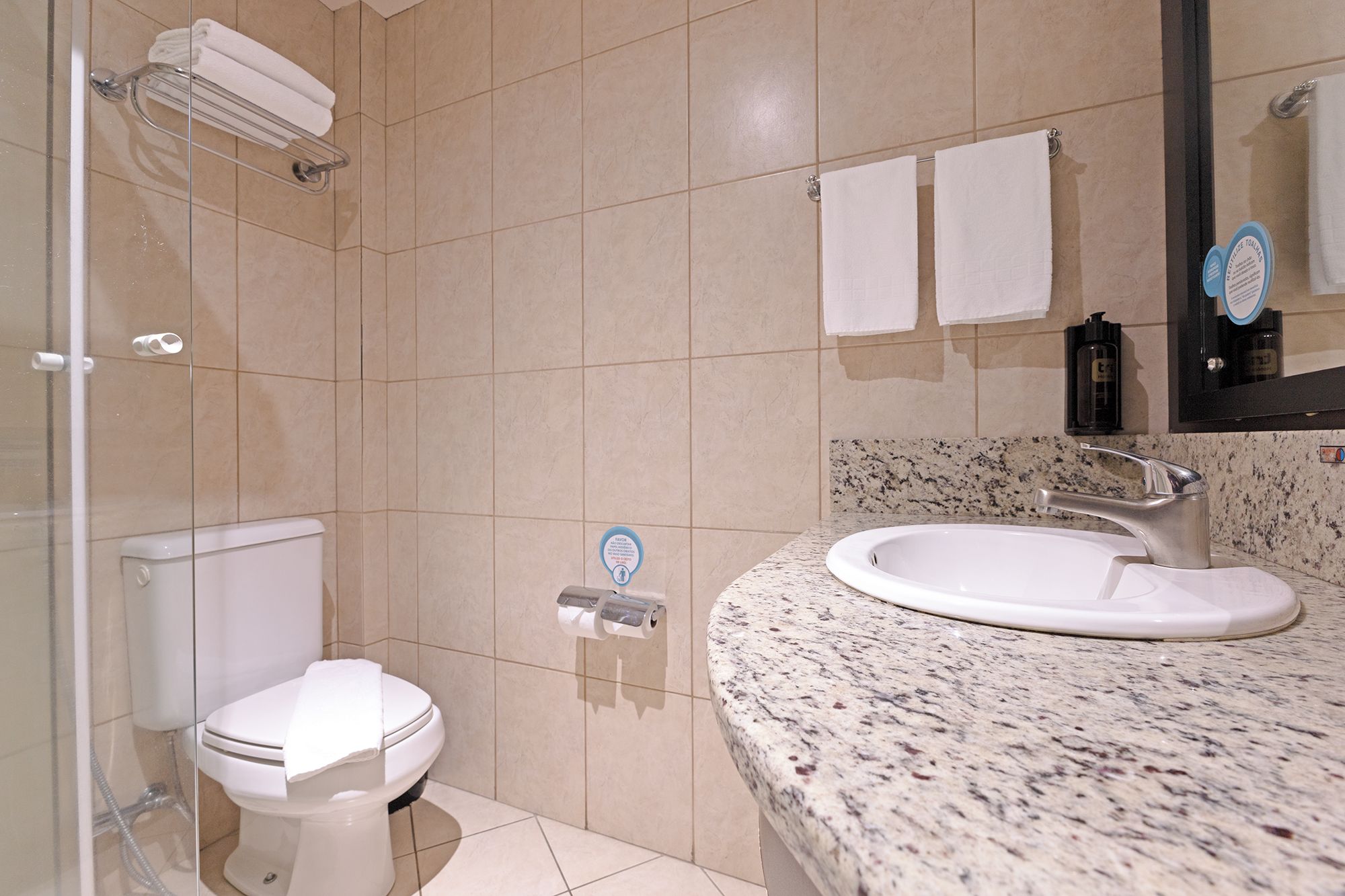 A bathroom with a toilet, sink, and shower.