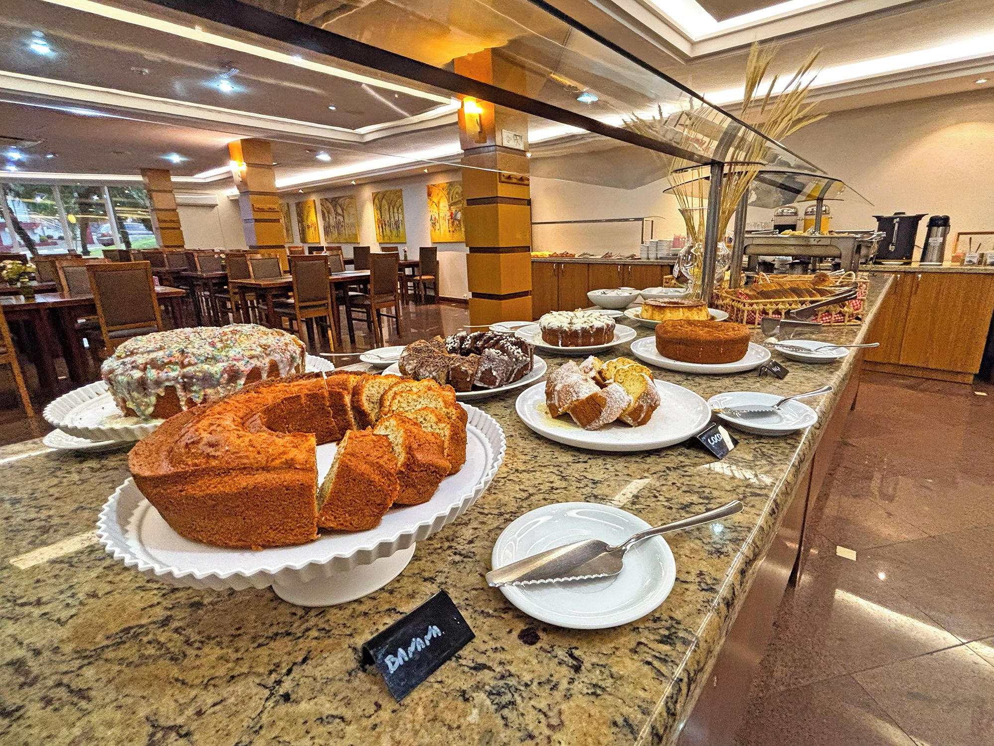 A buffet area with various baked goods displayed on plates and a sign indicating a special offer.